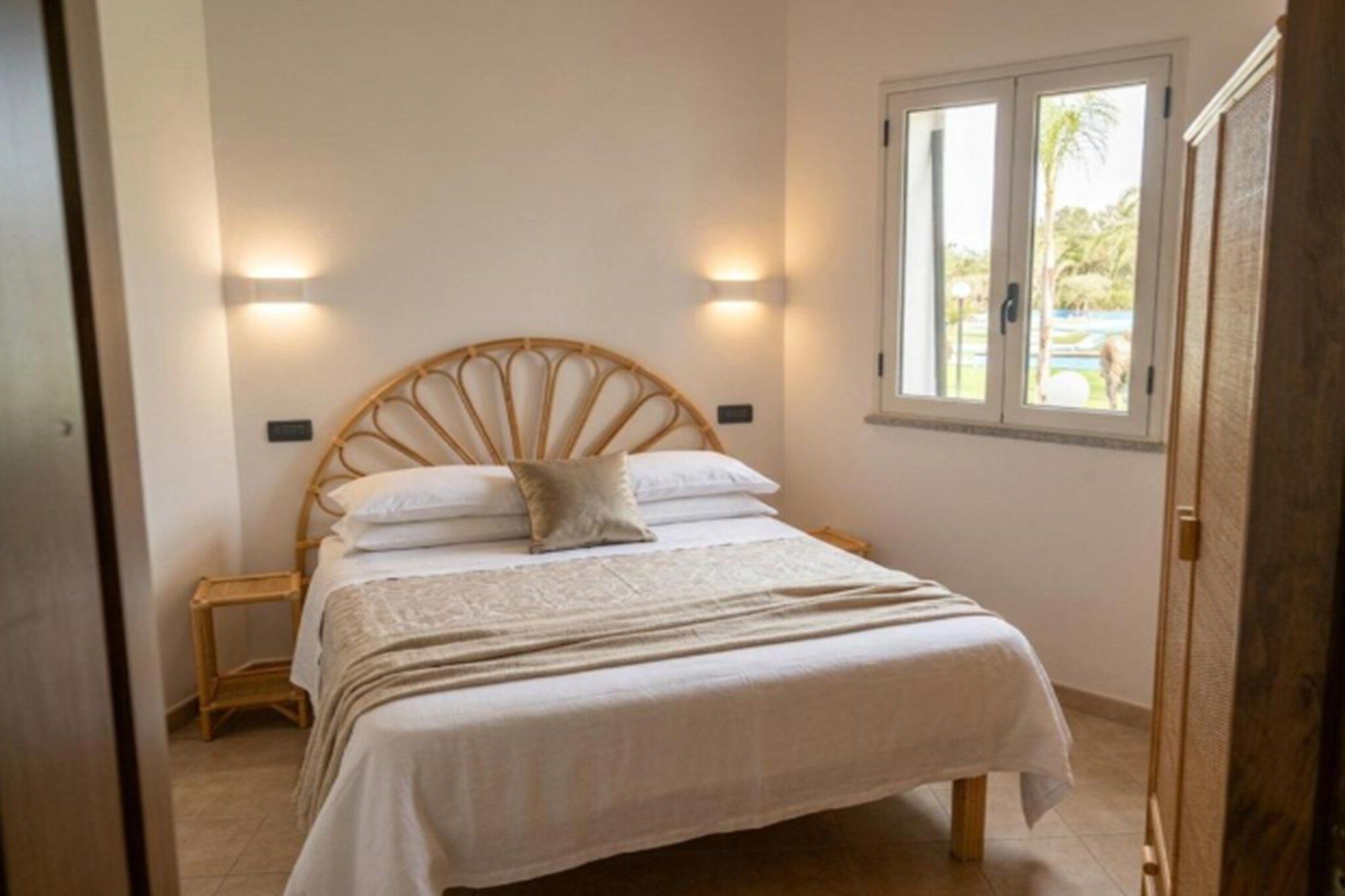 Une chambre à coucher avec un lit, des tables de chevet et une fenêtre.