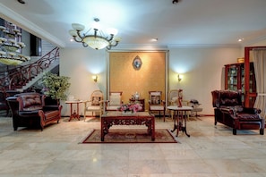 A spacious living room with a grand chandelier, a staircase, and a large window. - Cassa Dharmawangsa By ARBA (Jakarta)