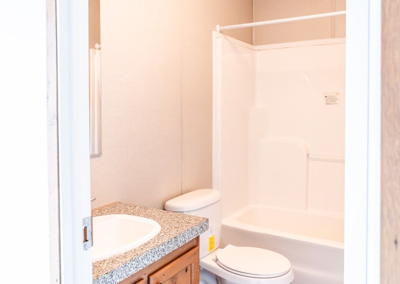 A bathroom with a sink, toilet, and shower area.