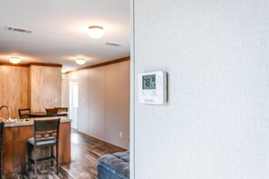 Een moderne keuken met houten kasten en een eethoek.