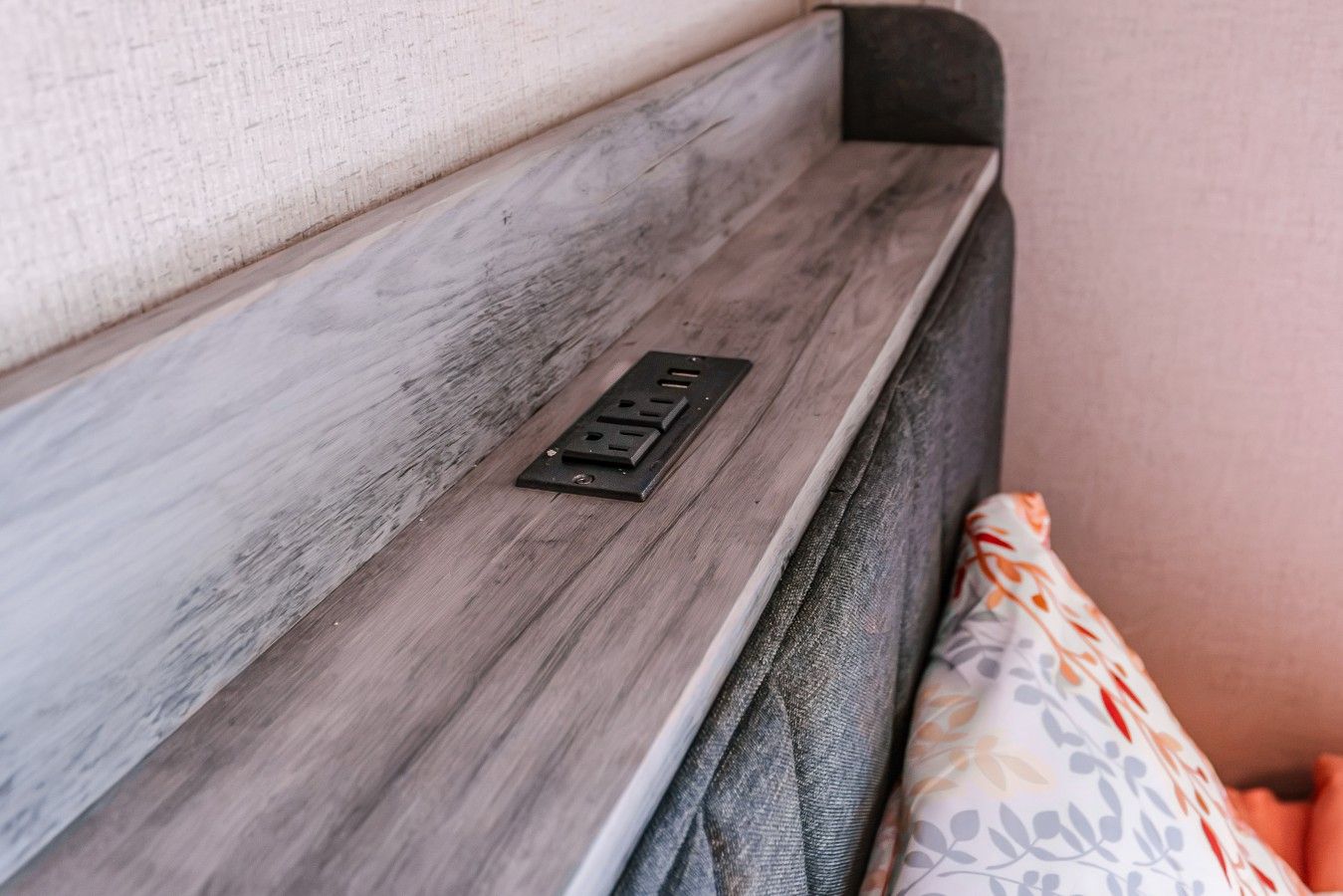 A close-up of a wooden panel with a metal plate, possibly a part of a room's interior design.