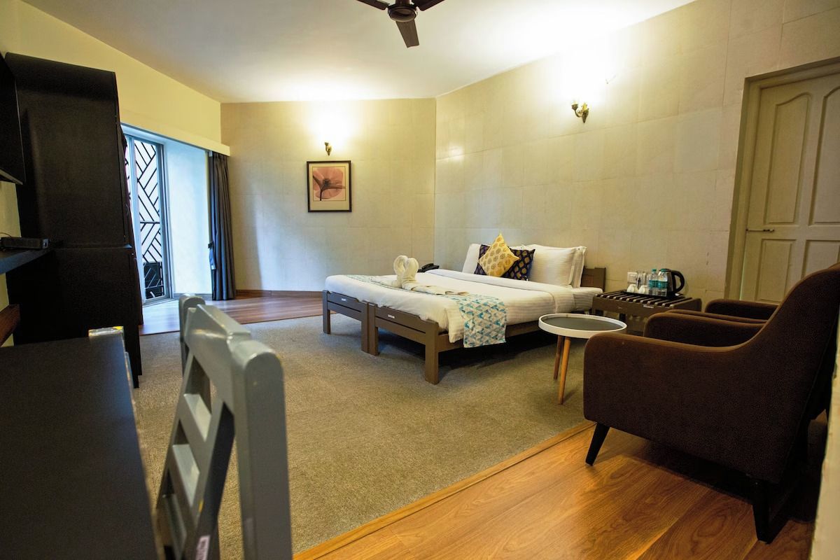 A room with a bed, a small table, a chair, and a desk.