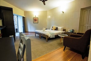 A room with a bed, a small table, a chair, and a desk. - Luna Spaces Hotel Bela Goa (Panaji)