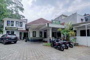 Un edificio con entrada cubierta, un cartel de Mulligan Golf & Carlu Cafe y motocicletas estacionadas.