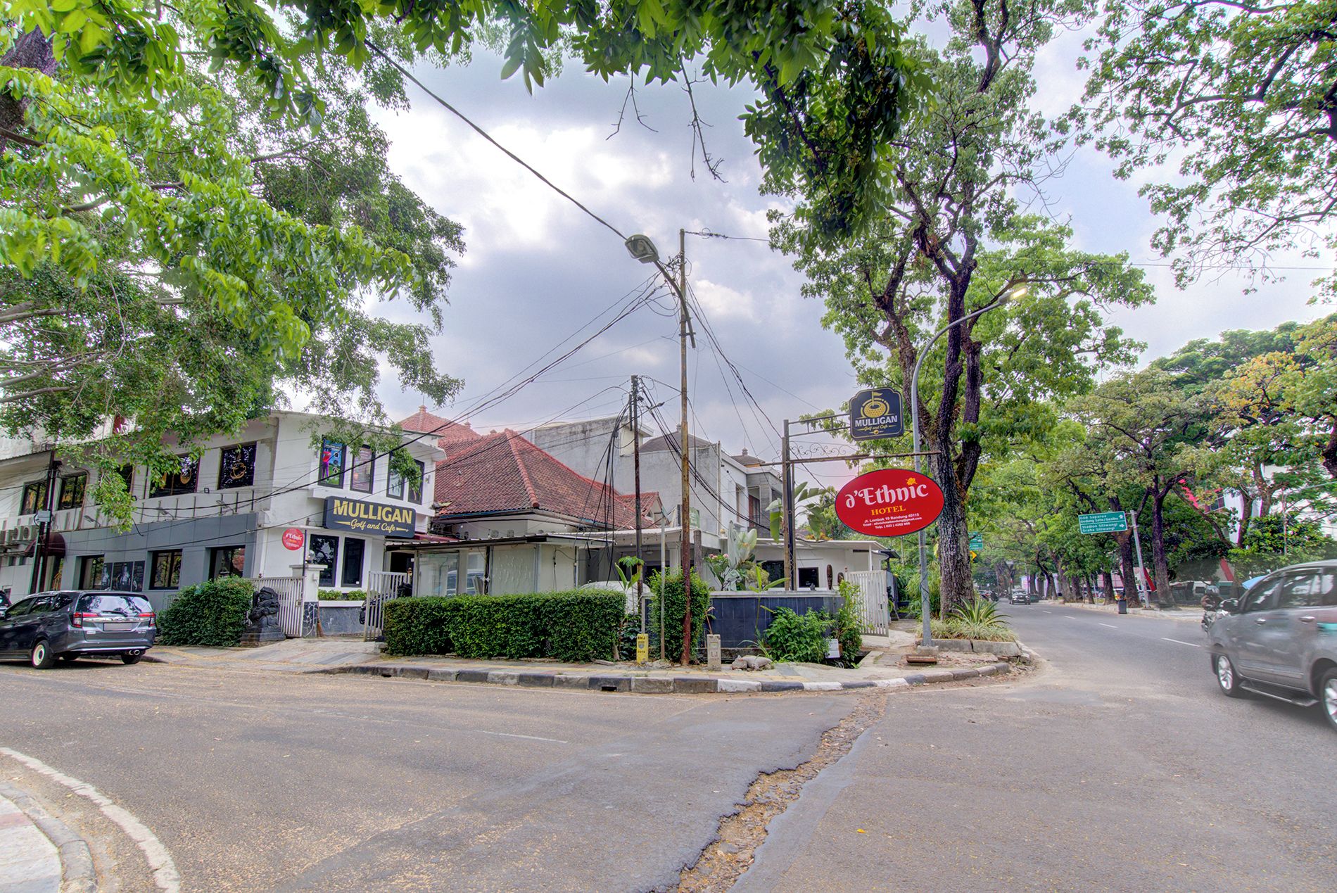 Une vue de rue avec un hôtel appelé « Ethnic Hotel » et un bâtiment portant l’inscription « Mulligan Golf and Cafe ».