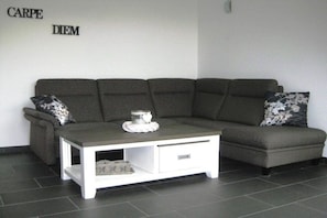 Un canapé gris avec une table basse blanche dans un salon moderne.