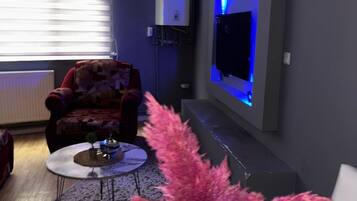 A living room with a sofa, a coffee table, and a decorative plant.