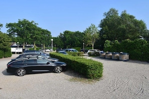 A parking lot with multiple cars and trash bins. - De Golbreker Type 1AC (Zoutelande)