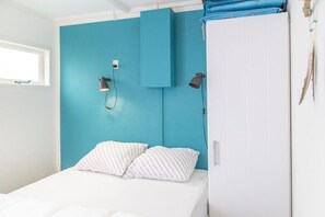 A bedroom with a bed, two bedside lamps, a window, and a wardrobe. - The Golf Breaker - Type 1 (Zoutelande)