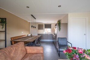 Un interior modern amb zona de dinar, cuina i espai per seure.