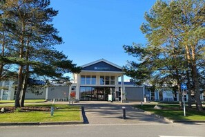 A building with a sign that reads 'Service Point' and a clear sky. - Holiday home "Zee Gras" (Kamperland)