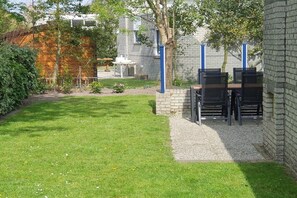 Een terras met buitenmeubels en een stenen muur.