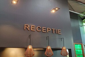 Un área de recepción con un cartel que dice 'RECEPTION' e iluminación colgante.