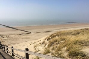 A beach with a wooden boardwalk leading to the shore. - Holiday apartment with 2 bedrooms (Koudekerke)