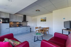 A compact living space with a kitchenette, dining area, and seating. - Holiday apartment with 2 bedrooms (Koudekerke)
