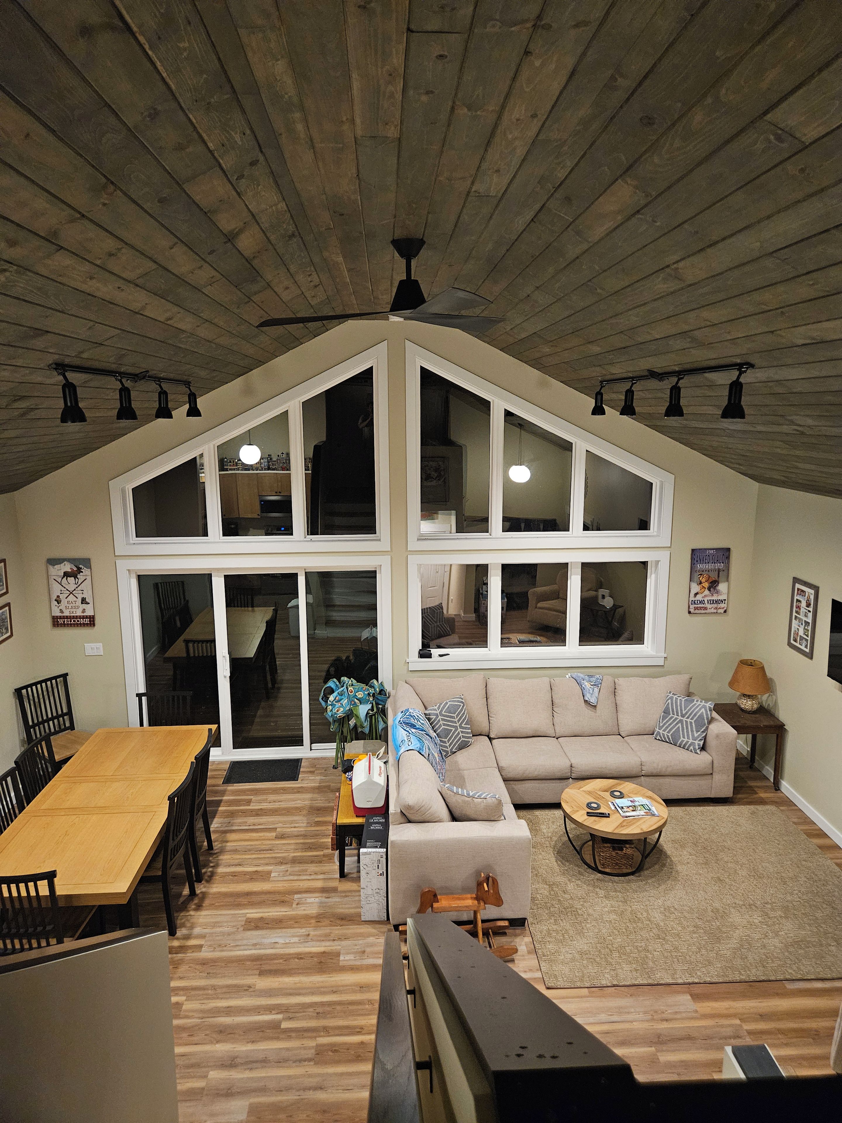 Ein geräumiges Loft mit hohen Decken, großen Fenstern, einer Essecke und einer gemütlichen Sitzecke.