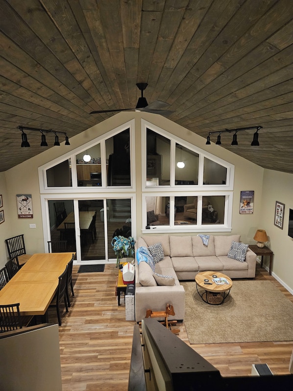 Ein geräumiges Loft mit hohen Decken, großen Fenstern, einer Essecke und einer gemütlichen Sitzecke.