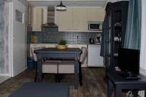 A compact kitchen with a dining table, a microwave, and a cabinet. - Holiday apartment in Zoutelande with Wi-Fi (Zoutelande)