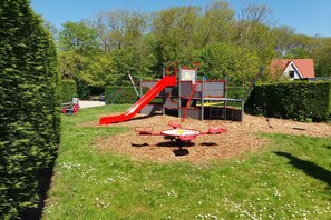 A playground with a red slide and a circular climbing structure. - Holiday apartment in Zoutelande with Wi-Fi (Zoutelande)