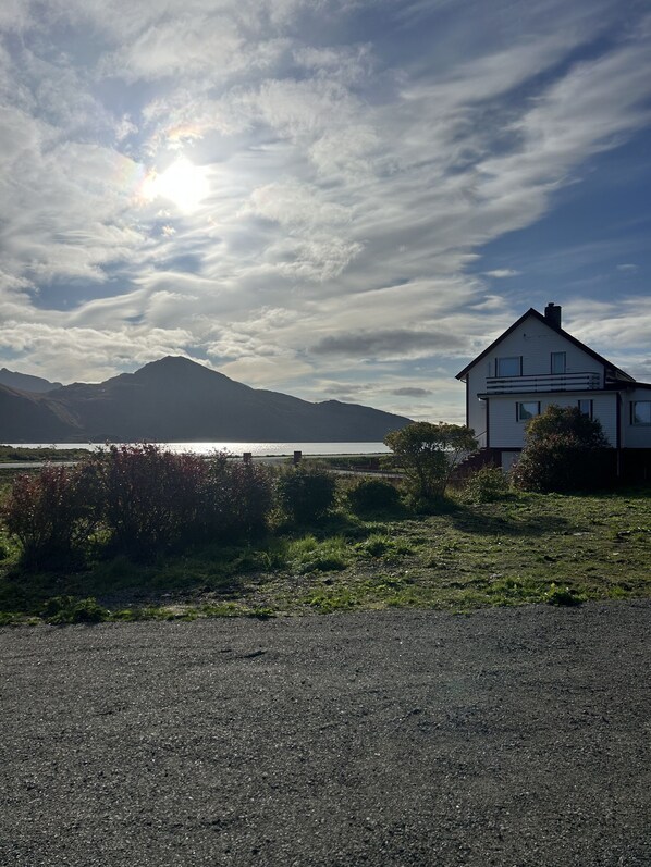 Ein Haus mit Blick auf einen See und Berge im Hintergrund.