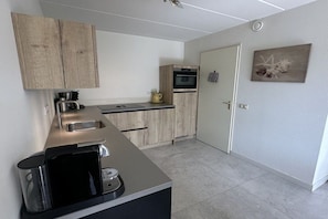 Een moderne keuken met een zwart aanrecht, houten kastjes en een ingebouwde oven.