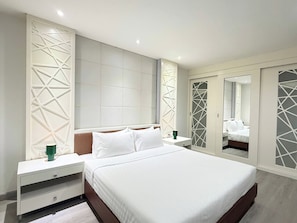 A modern bedroom with a large bed, nightstands, a dresser, and a wardrobe with geometric patterns. - TC Contel at Charan Phrom Phong - Ginger (Bangkok)