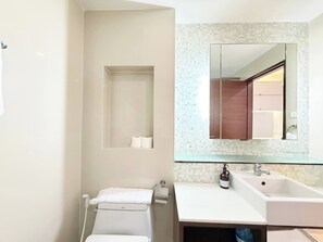 A bathroom with a white sink, a mirror, and a towel rack. - TC Contel at Charan Phrom Phong - Ginger (Bangkok)