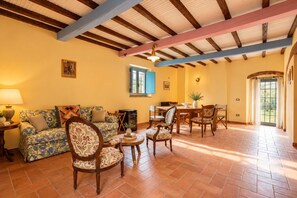 Una sala de estar con sofá, sillas, una mesa de comedor y chimenea.