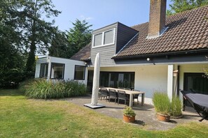 A residential property with a patio area, outdoor seating, and a chimney.