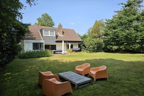A house with a patio, a dining area, and a lawn.