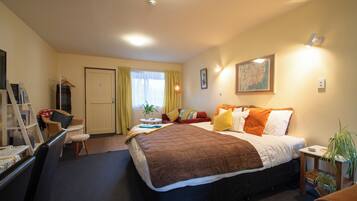 Ein Hotelzimmer mit Bett, Schreibtisch, Stuhl, Kleiderschrank und einer Karte an der Wand.