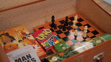 A chessboard with pieces, a 'UNO' game box, and a 'Man Bites Dog' book.
