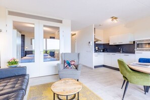 A modern apartment with a living room, a dining area, and a kitchen. - Residence Ruimzicht 35 (Domburg)