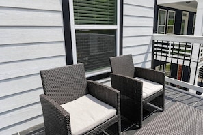 Two wicker chairs with cushions on a balcony with a white railing. - Luxury for 2 Traveling for Business (Atlanta,)