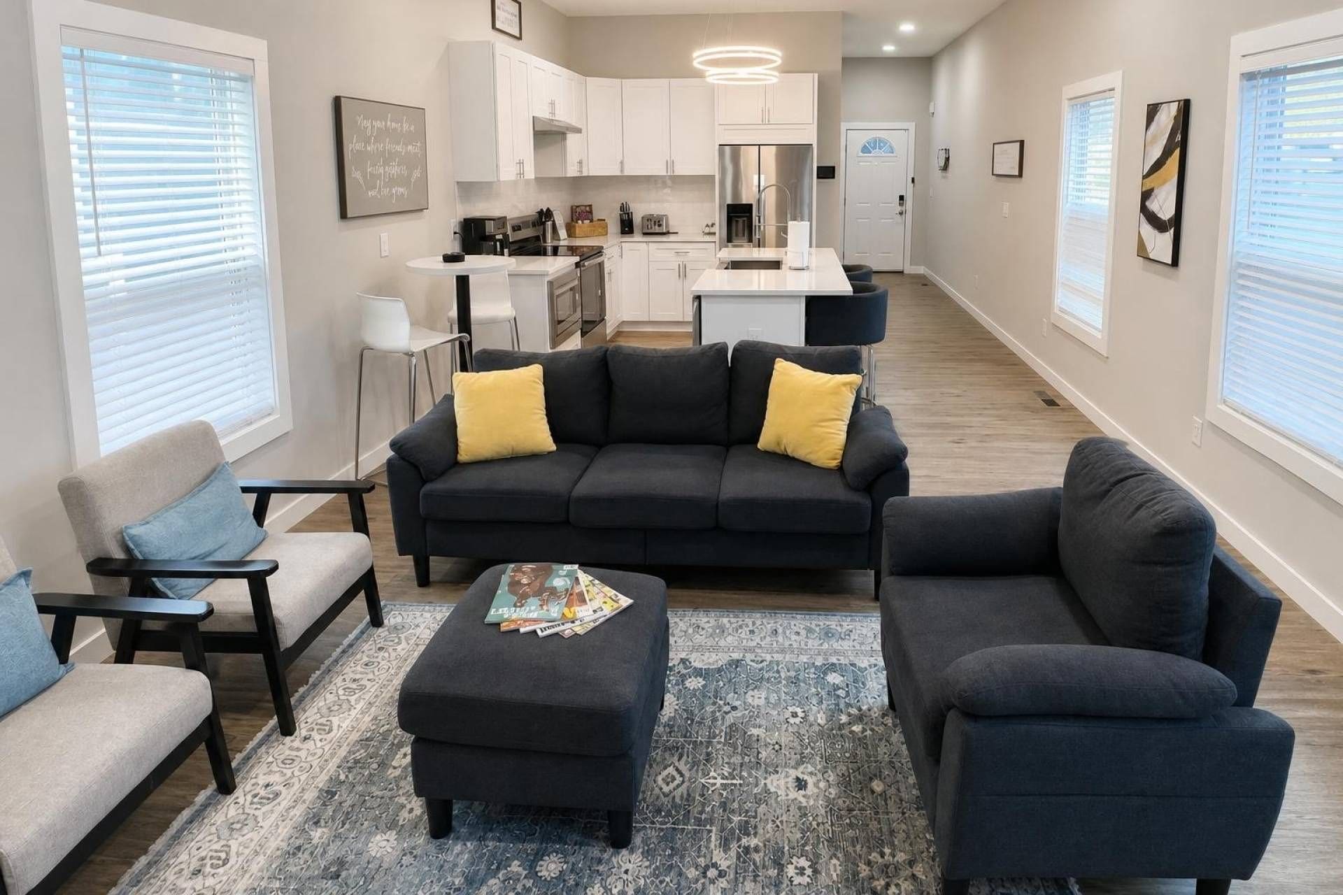 A modern living room with a dark-colored sofa set, a coffee table, and a patterned rug.