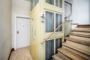 A staircase with a wooden handrail and beige walls. - Rondinella (Florence)