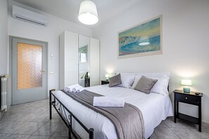 A neatly arranged bedroom with a bed, bedside tables, a mirror, and a painting on the wall. - Rondinella (Florence)