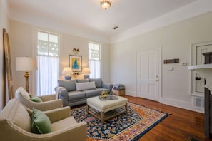 A living room with a sofa, armchair, coffee table, and patterned rug. - Austin (Mobile)