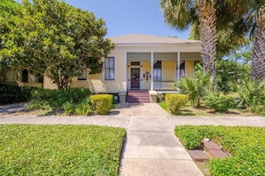 A two-story house with a front porch, a driveway, and well-maintained landscaping. - Austin (Mobile)