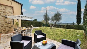 An outdoor patio with stone walls, a table set for dining, and a view of the countryside. - Il Mirto - 3 Bedroom villa, pool & AC by Pelagone Golf, Gavorrano near the coast (Gavorrano)
