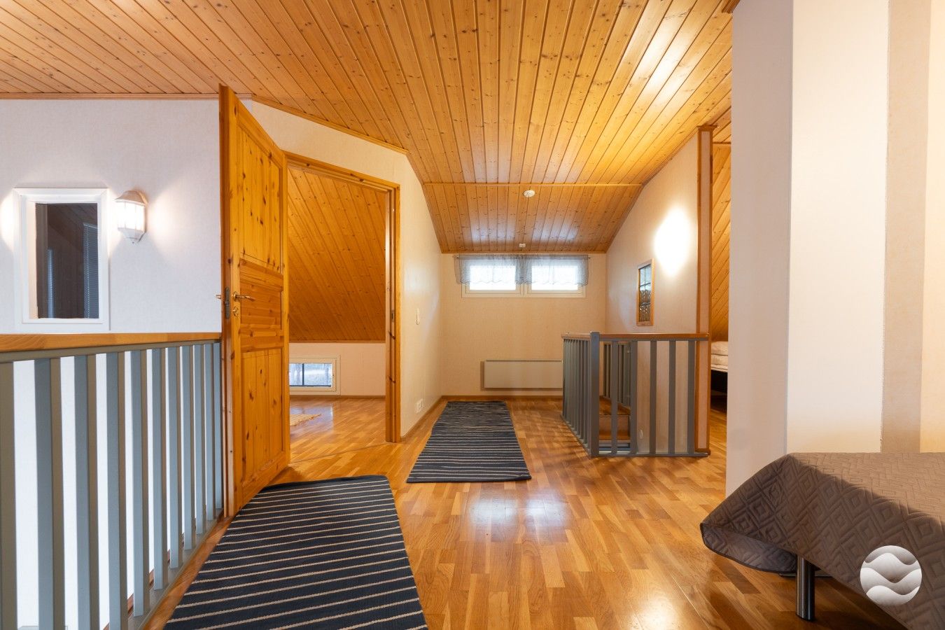 Ein geräumiger Flur mit Holzboden, einer Holztür und einem Fenster.