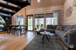 Een moderne woonkamer met een eethoek, een bank en een trap.