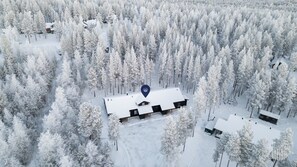 Lumipeitteisen metsän ilmakuvassa näkyy myös mökkialue.