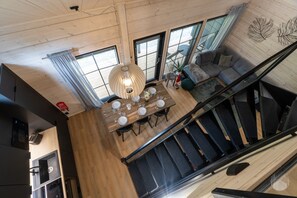A modern interior with a dining area, staircase, and a view of the outdoors. - Yläkasi A by Holiday in Lapland (Levi)