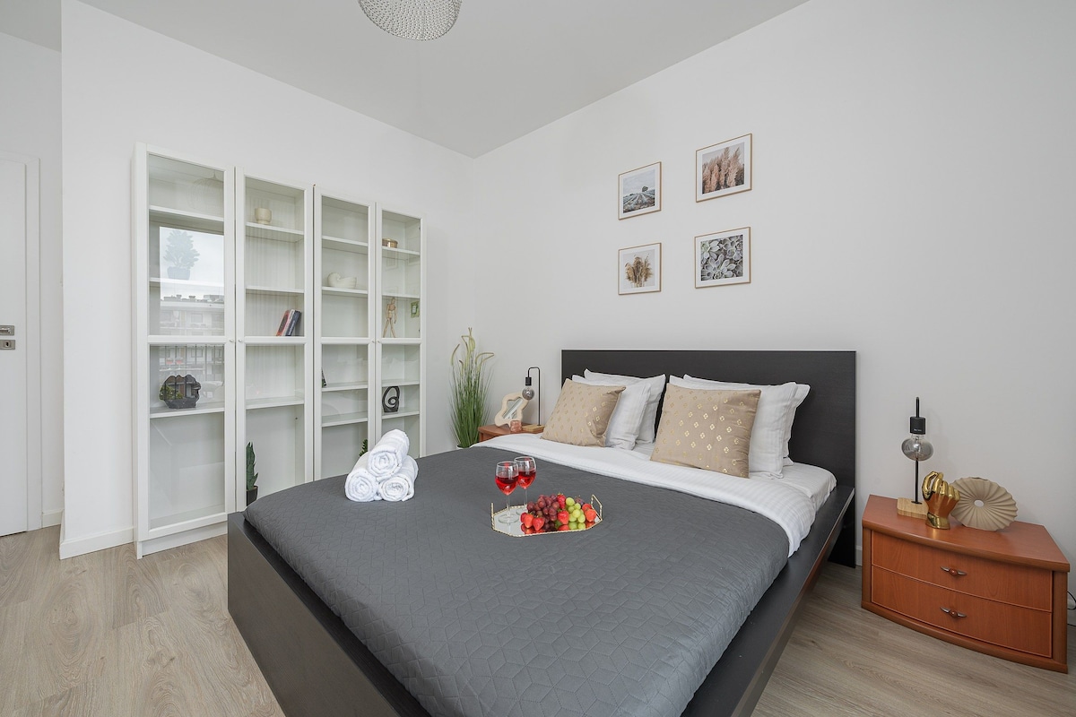 Een slaapkamer met een groot bed, een kledingkast en een nachtkastje.