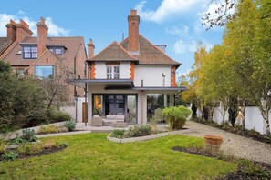 A residential property with a modern house, a covered patio, and a well-maintained garden. - MUR1 - Modern 6-bed House in Wimbledon (London)