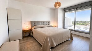 A bedroom with a bed, bedside tables, a wardrobe, and a large window with a view. - RDR557- Penthouse w. Scenic Views | Sleeps 6 (Estepona)