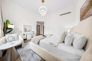 Ein modernes Schlafzimmer mit einem Bett, einem Schreibtisch, einem Stuhl und einem großen Spiegel.