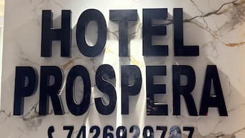 A marble wall with the text 'HOTEL PROSPERA' and a phone number.
