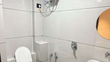 A bathroom with a toilet, a sink, a shower, and a blue bucket.